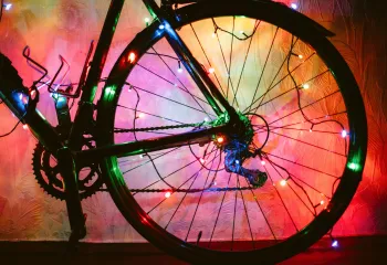A bicycle wheel decorated with colourful lights.