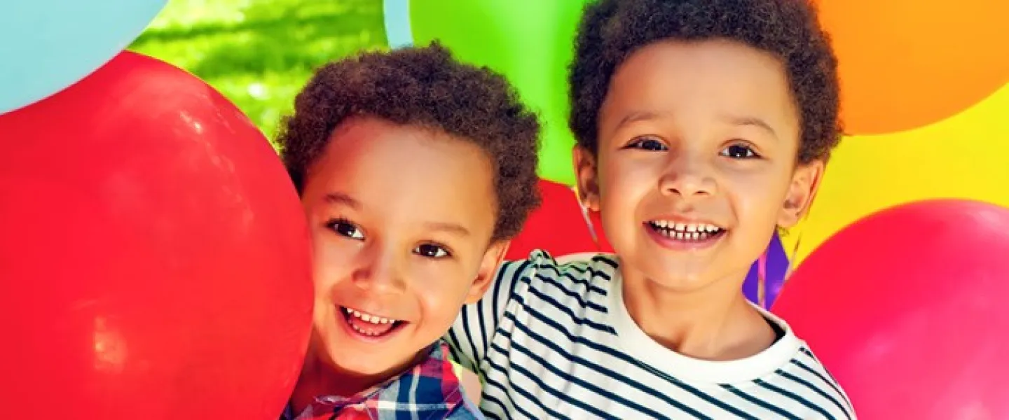 Two boys surrounded by brightly coloured balloons