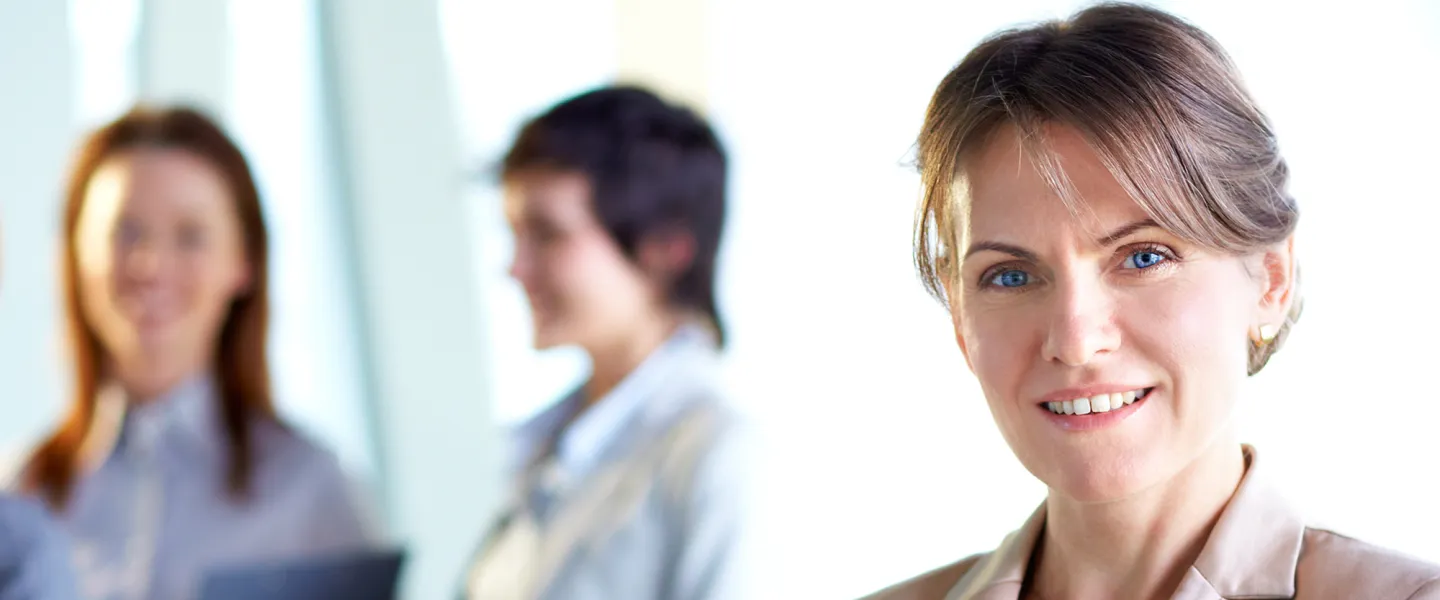 A business woman looks directly at the camera.