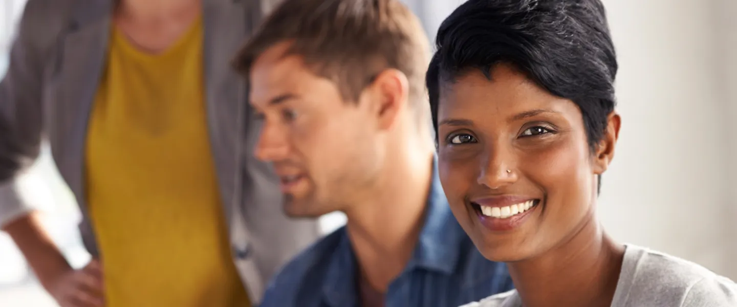 A smiling woman looks directly into the camera.