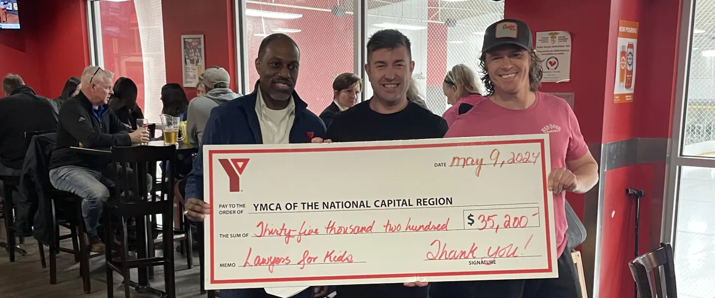 Three people, including Y CEO Trevor McAlmont, holding a large cheque that reads "YMCA of the National Capital Region. 35,200. Lawyers for Kids. Thank you!"