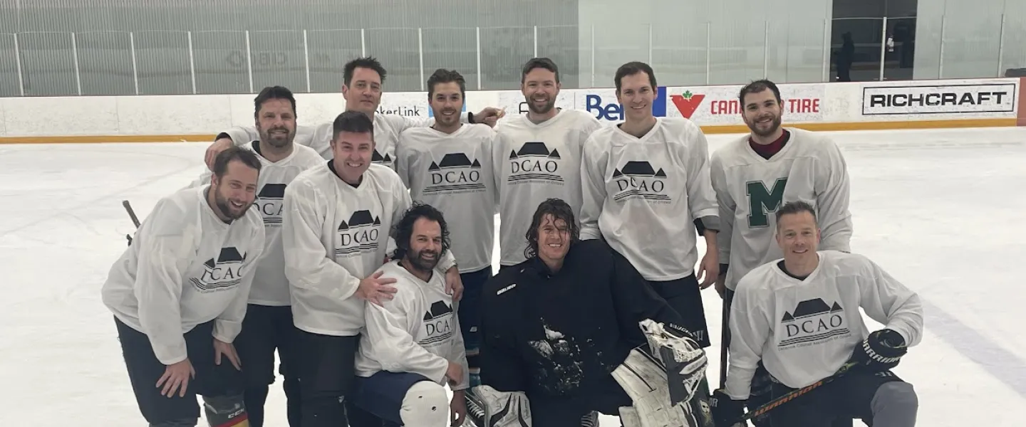 Hockey team photo in white jerseys with the DCAO logo