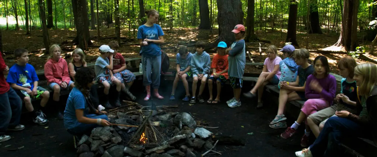 Campers sit around a campfire.