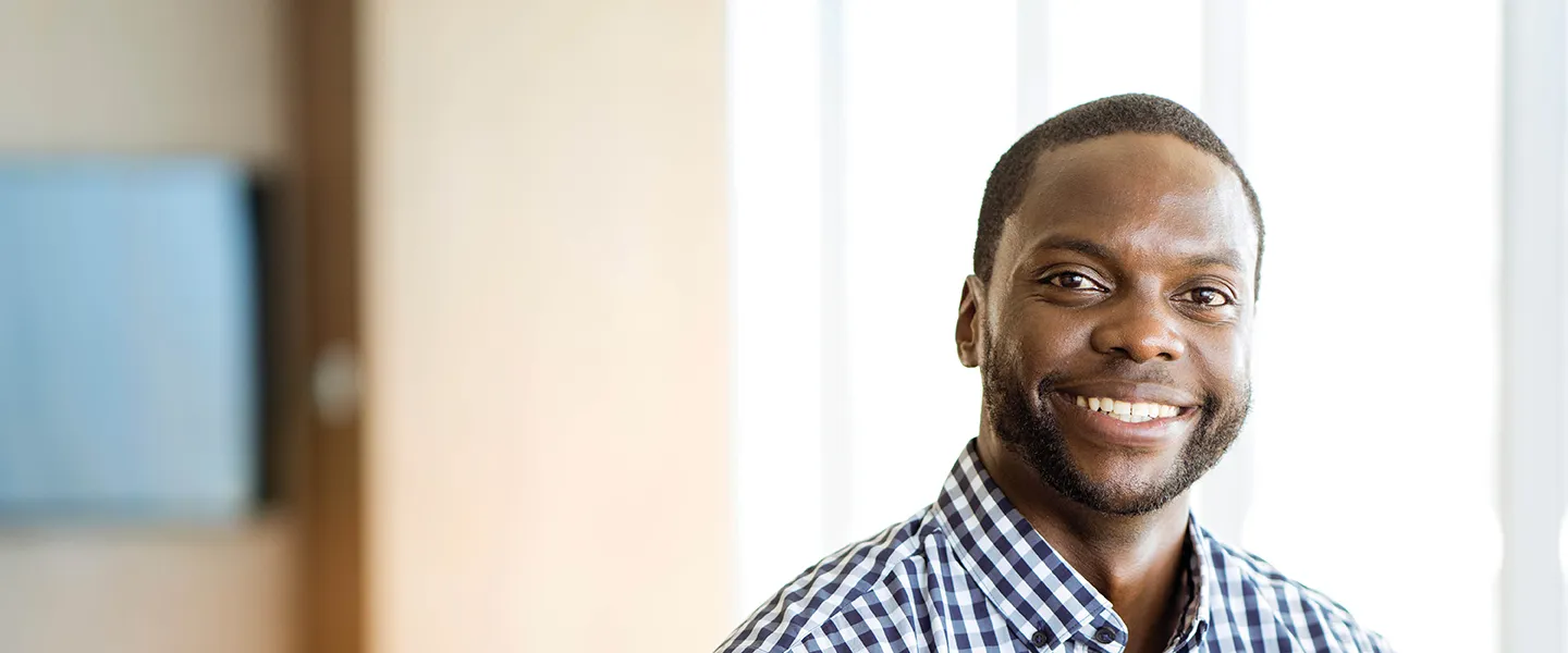 A smiling man in a classroom setting.