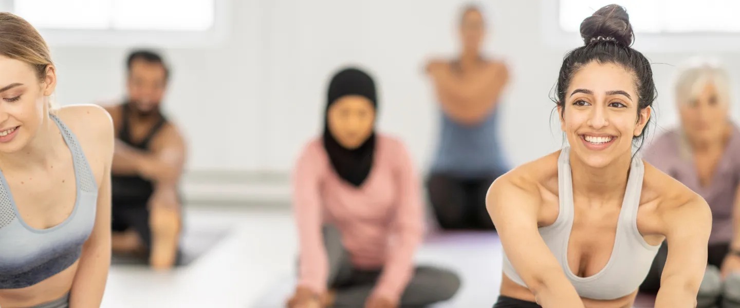 A woman smiles in a group fitness class.