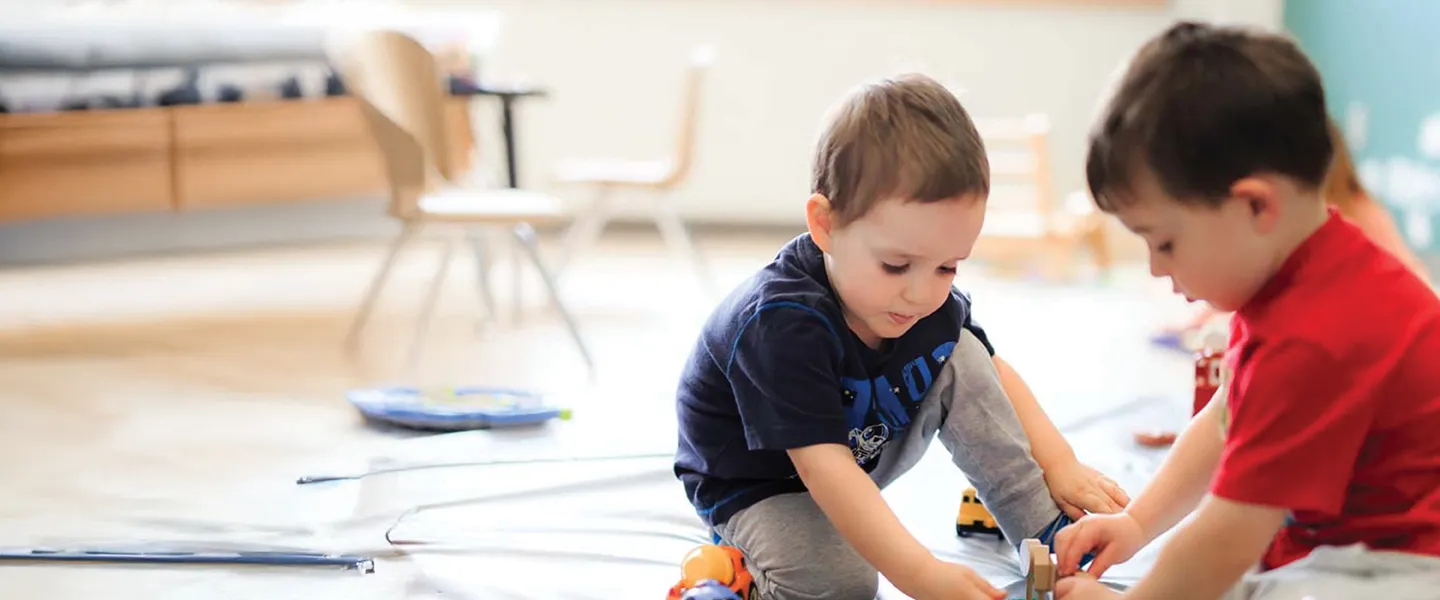 Two children play on the floor.