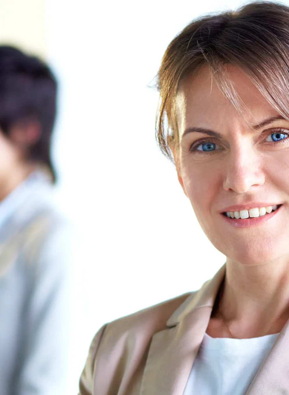 A business woman looks directly at the camera.