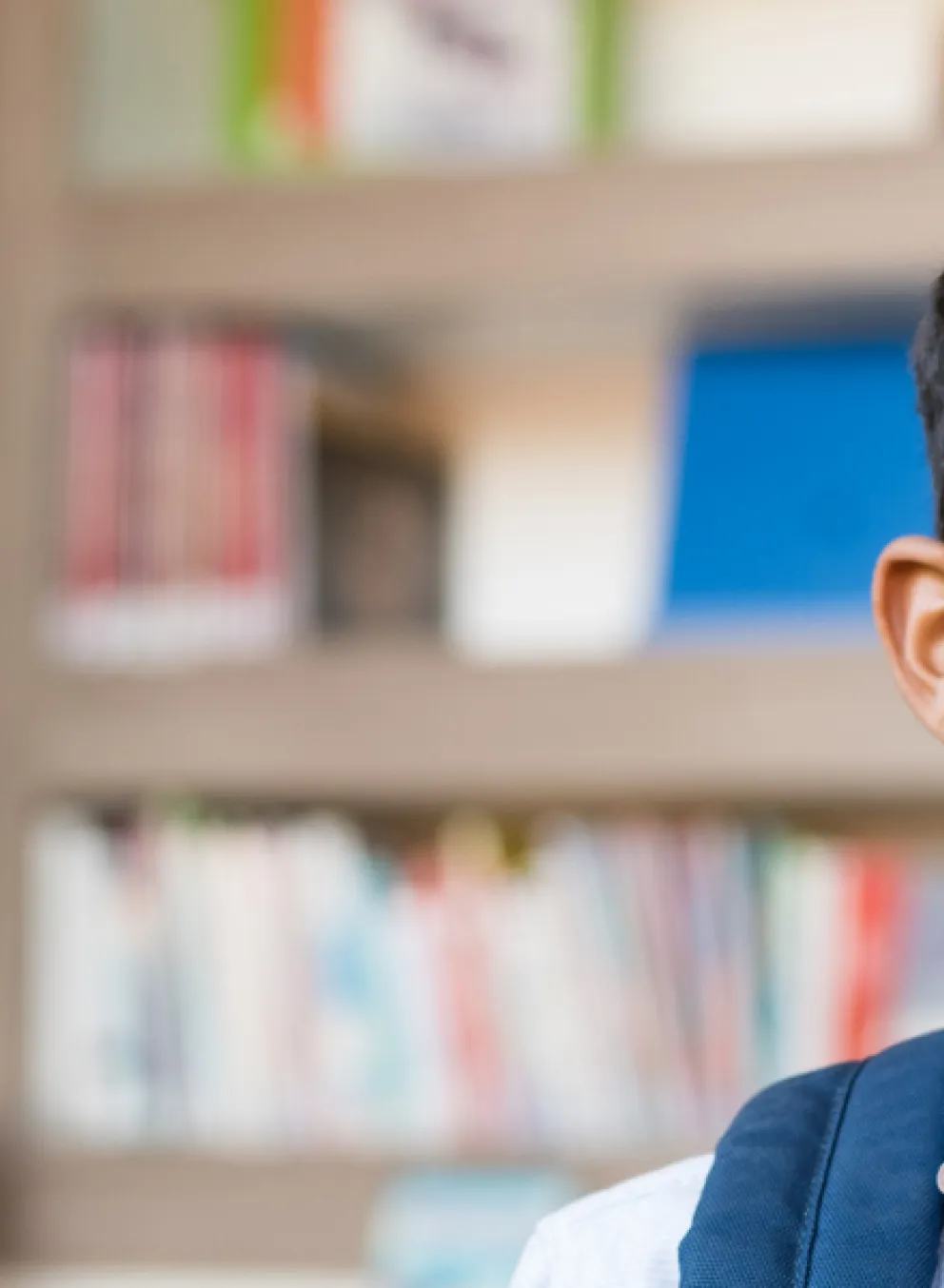 A young boy smiles in a library.