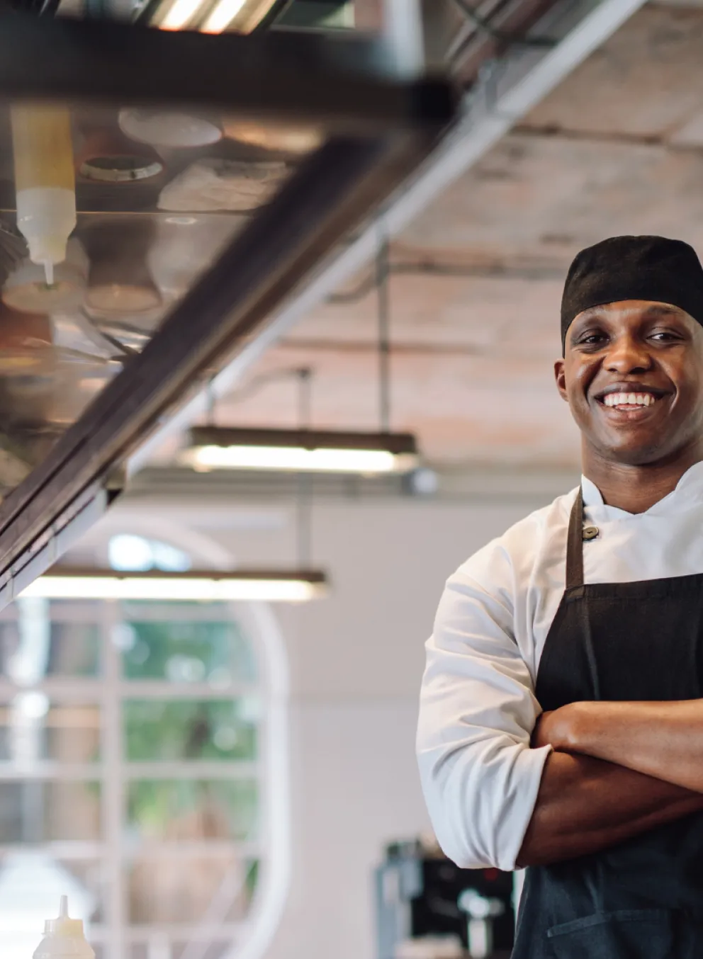 A chef smiling with his arms crossed