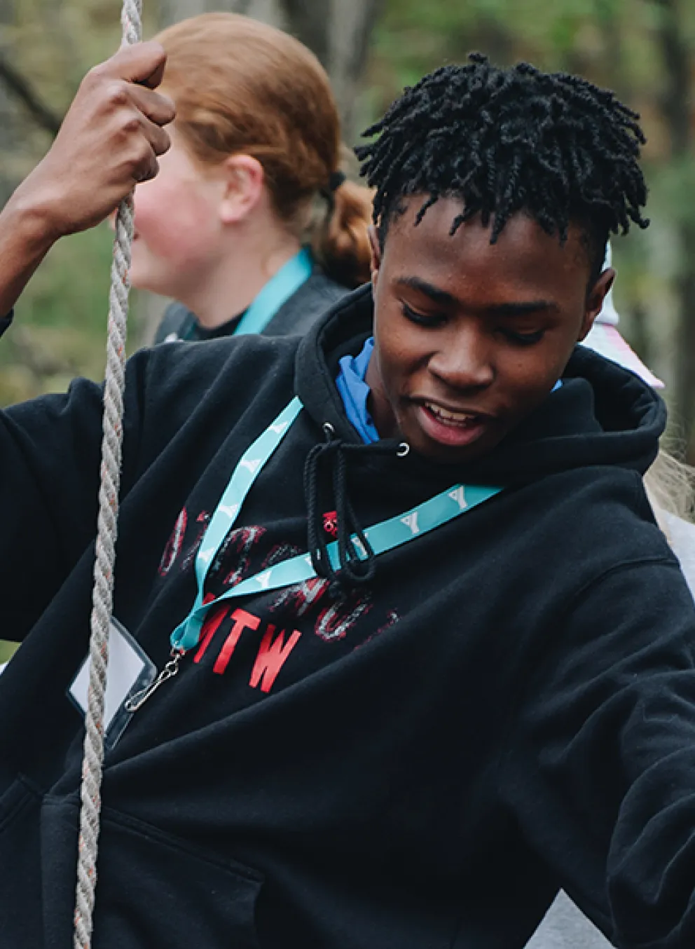 A team of people enthusiastically participating in a rope game, showcasing teamwork and fun in an open area.