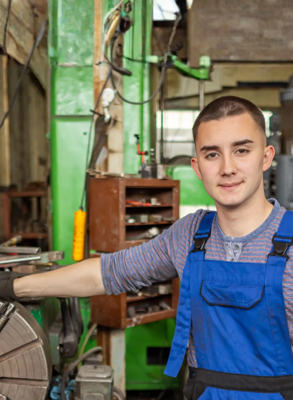 A man surrounded by tools and equipment in a workshop