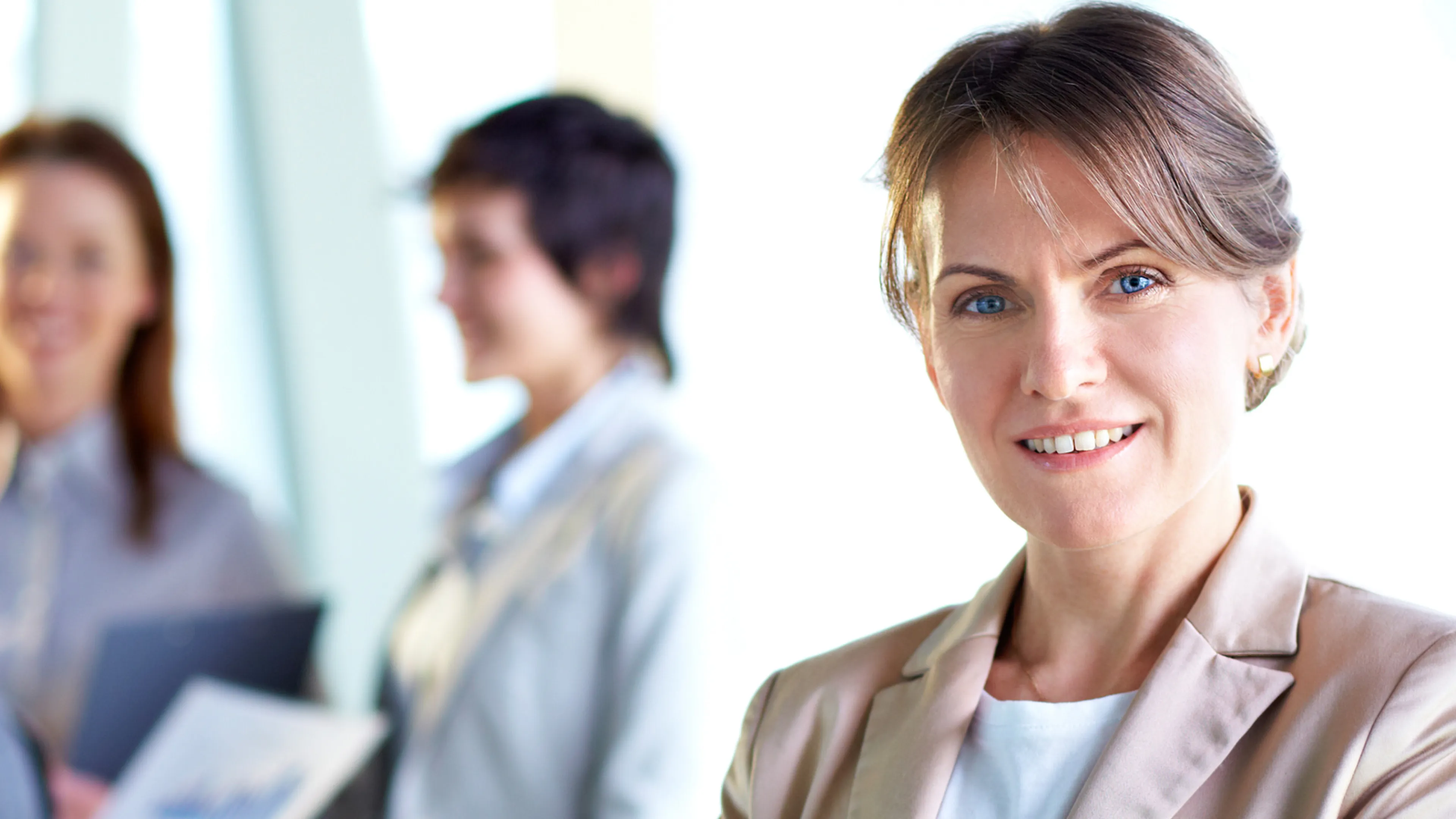 A business woman looks directly at the camera.