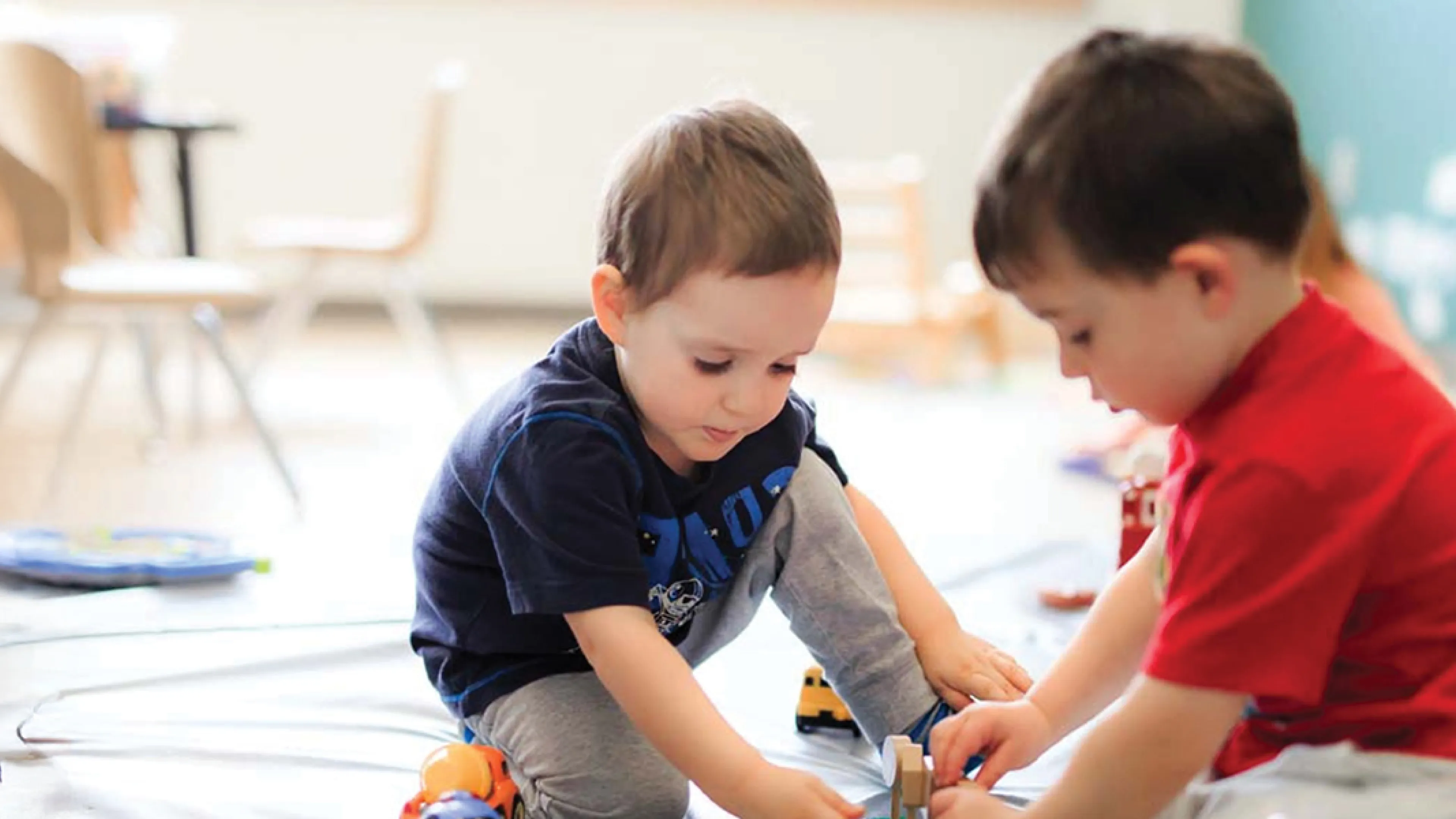 Two children play on the floor.