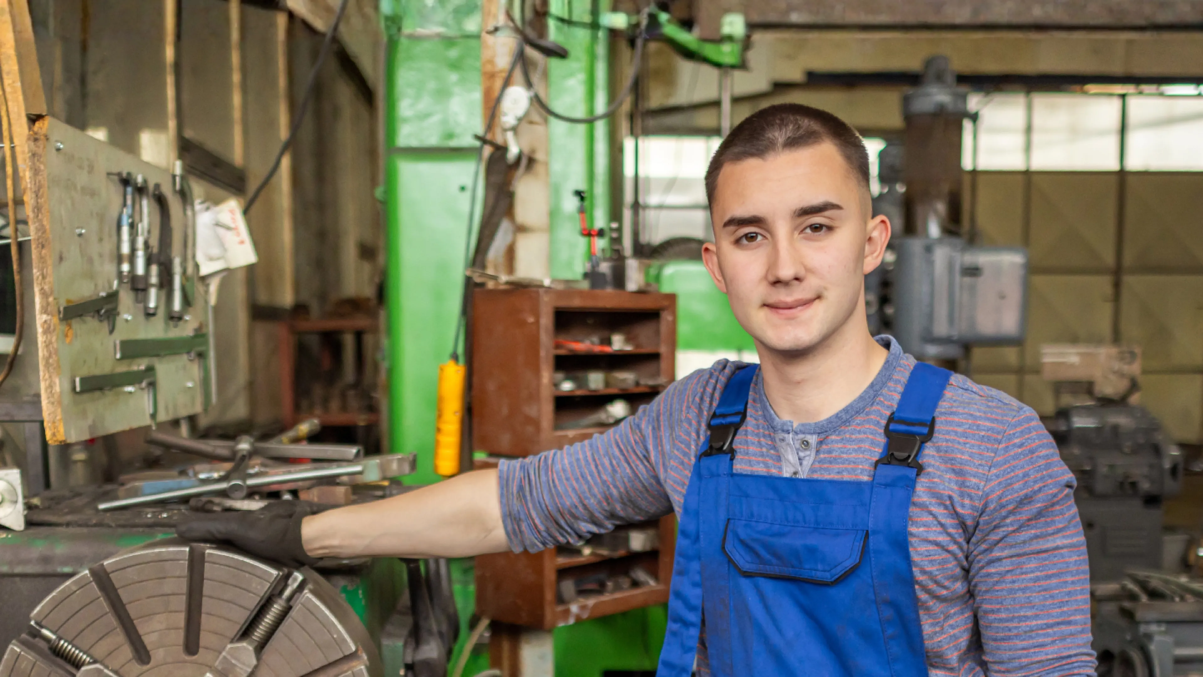 A man surrounded by tools and equipment in a workshop