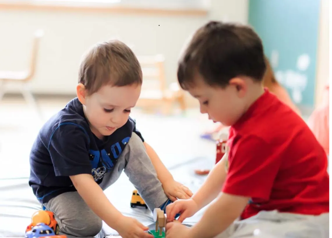 Two children play on the floor.