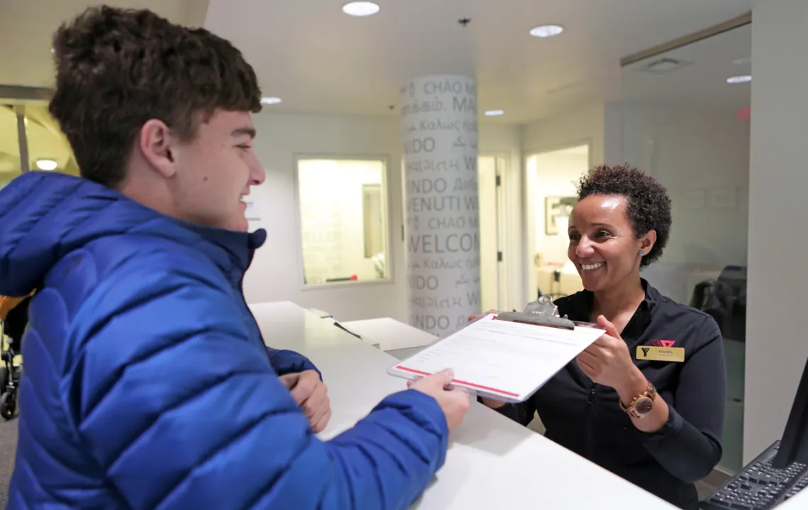 A YMCA Membership Sales and Services staff member welcomes a new member.