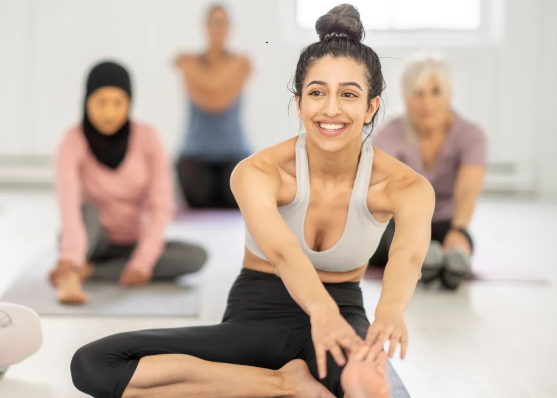 A woman smiles in a group fitness class.