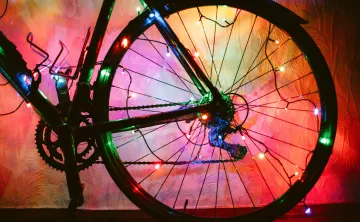 A bicycle wheel decorated with colourful lights.