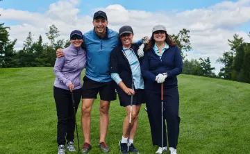 A group photo of four golfers on a course